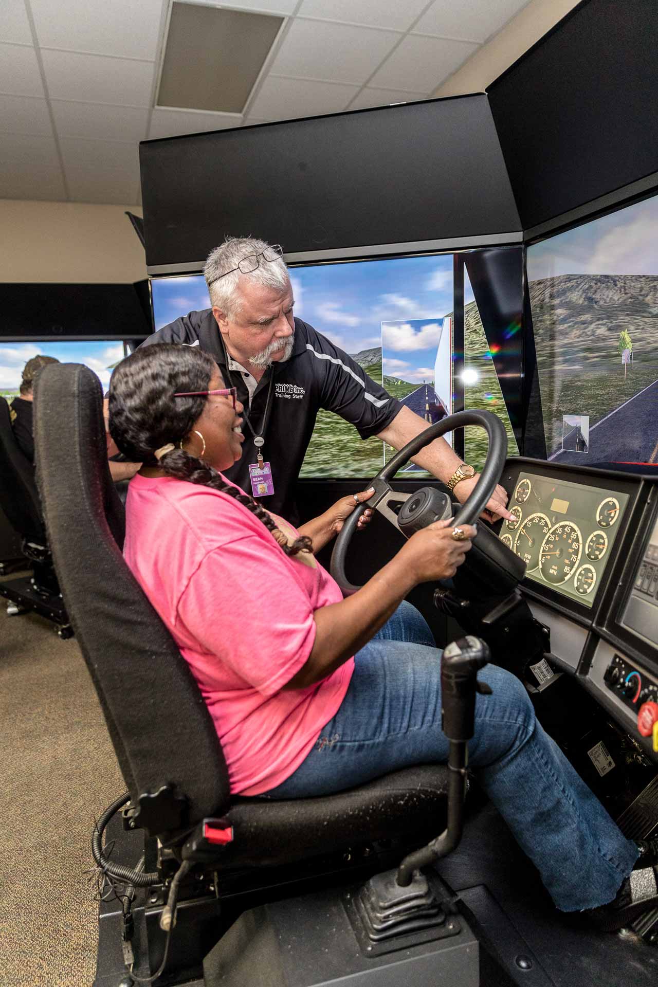 A Prime driving instructor showing a student driver something during a driving simulation.